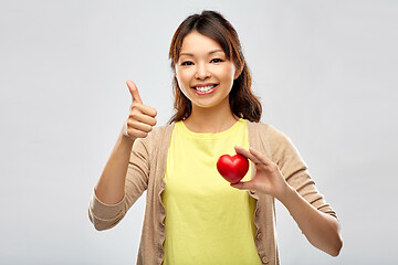 Image showing happy asian woman with red heart showing thumbs up