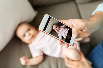 Image showing father with smartphone taking picture baby at home