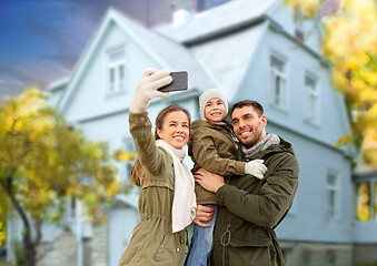 Image showing family taking selfie by smartphone house in autumn