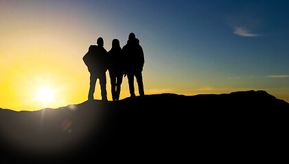 Image showing group of travellers with backpacks over sunrise