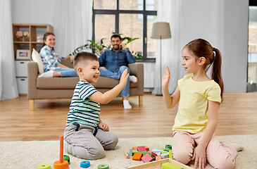 Image showing brother and sister playing toy blocks at home