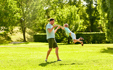 Image showing happy father and son having fun at summer park