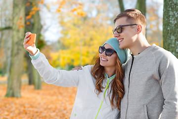 Image showing couple taking selfie by smartphone in autumn park