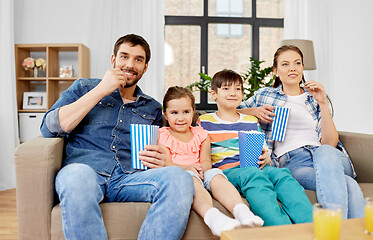 Image showing happy family with popcorn watching tv at home