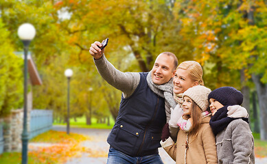 Image showing happy family with camera in autumn park