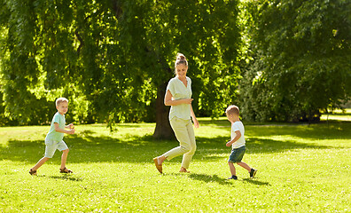 Image showing mother with sons playing catch game at summer park