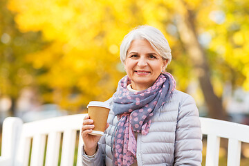 Image showing senior woman drinking coffee in autumn park