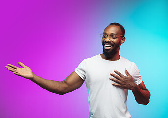 Image showing African-american young man\'s portrait on gradient studio background in neon