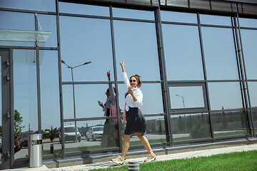 Image showing Young woman walking against glass\' wall in airport, traveler with small baggage, influencer\'s lifestyle