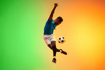 Image showing Male soccer, football player training in action isolated on gradient studio background in neon light