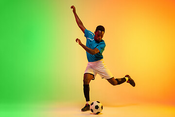 Image showing Male soccer, football player training in action isolated on gradient studio background in neon light