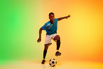 Image showing Male soccer, football player training in action isolated on gradient studio background in neon light