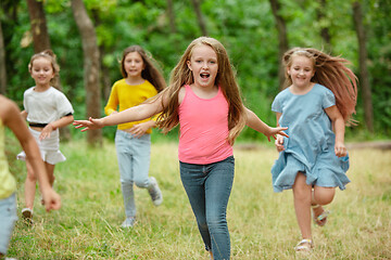 Image showing Kids, children running on green meadow, forest. Childhood and summertime