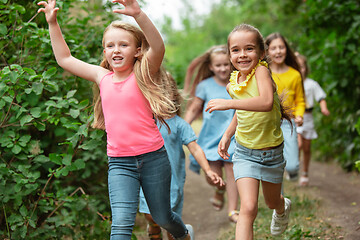 Image showing Kids, children running on green meadow, forest. Childhood and summertime