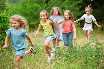 Image showing Kids, children running on green meadow, forest. Childhood and summertime