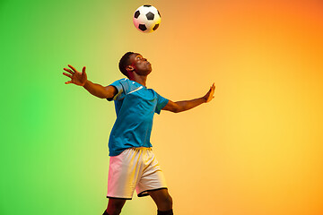 Image showing Male soccer, football player training in action isolated on gradient studio background in neon light