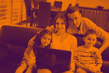 Image showing happy young family have fun and working on laptop at home