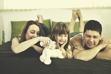 Image showing happy family relaxing in bed