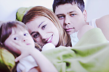 Image showing happy family relaxing in bed