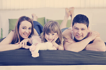 Image showing happy family relaxing in bed