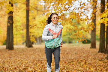 Image showing young woman running in autumn park