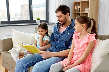 Image showing happy father with daughters reading book at home