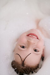 Image showing little girl in bath playing with soap foam