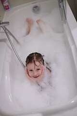 Image showing little girl in bath playing with soap foam