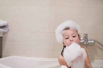 Image showing little girl in bath playing with soap foam