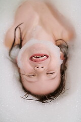 Image showing little girl in bath playing with soap foam