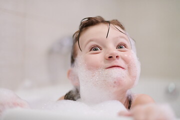 Image showing little girl in bath playing with soap foam