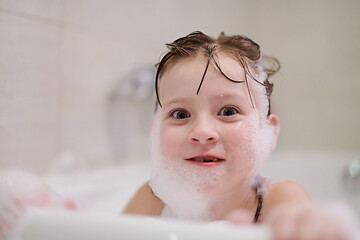 Image showing little girl in bath playing with soap foam