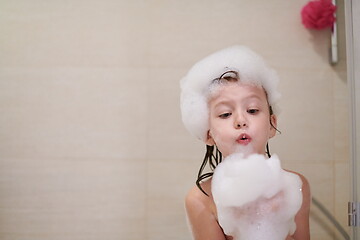 Image showing little girl in bath playing with soap foam