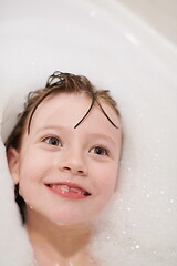 Image showing little girl in bath playing with soap foam