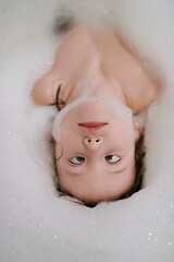 Image showing little girl in bath playing with soap foam