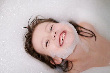 Image showing little girl in bath playing with soap foam