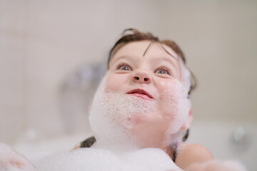 Image showing little girl in bath playing with soap foam