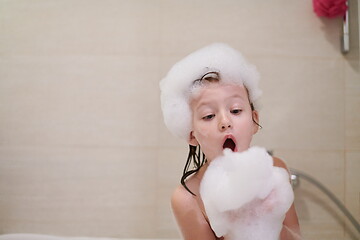 Image showing little girl in bath playing with soap foam