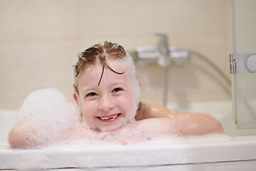 Image showing little girl in bath playing with soap foam