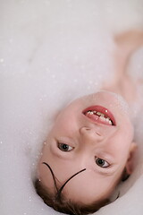 Image showing little girl in bath playing with soap foam