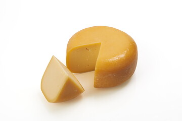 Image showing whole round and one peace of organic produced cheese