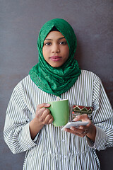 Image showing african muslim businesswoman with green hijab using mobile phone