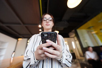 Image showing portrait of businesswoman with glasses using mobile phone