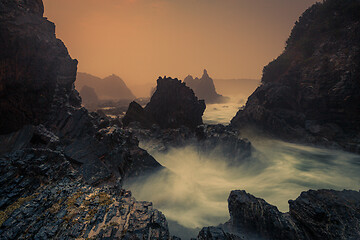 Image showing Sea fog and sunrise on sharp craggy coastline