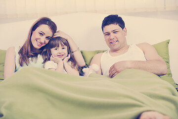 Image showing happy family relaxing in bed