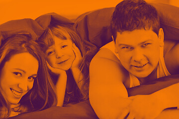 Image showing happy family relaxing in bed