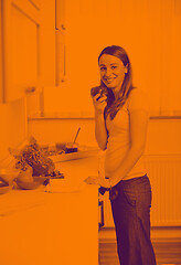 Image showing happy young  woman with apple in kitchen