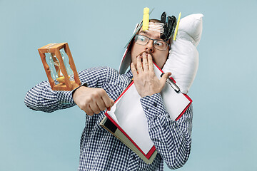 Image showing Tired man sleeping at home having too much work. Bored businessman with pillow