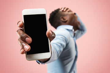 Image showing Beautiful man looking suprised and bewildered isolated on pink