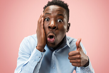 Image showing The young attractive man looking suprised isolated on pink